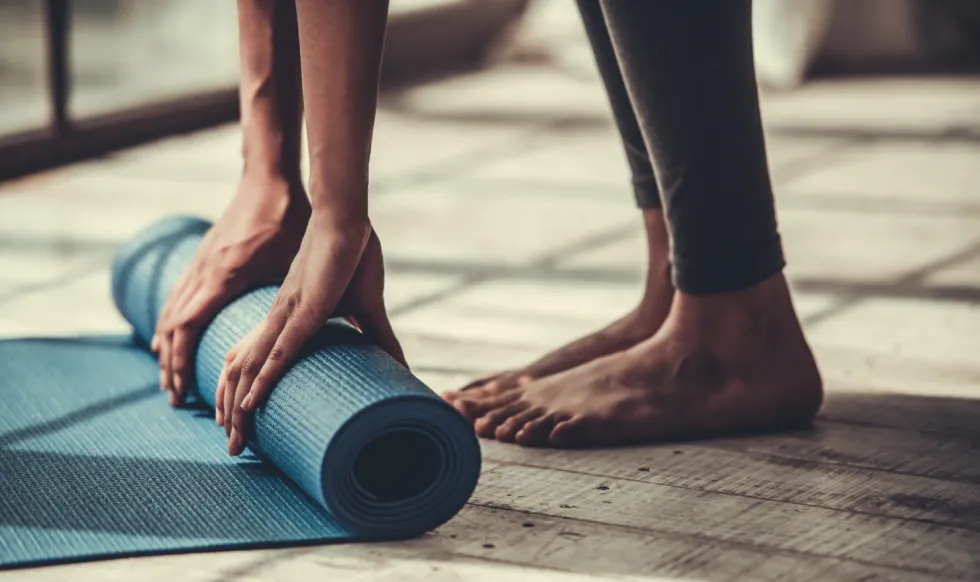 person standing with yoga mat