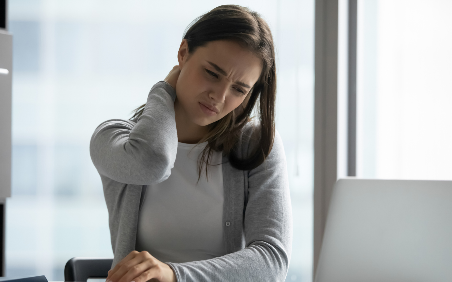 Image depicting girl sitting at desk with neck pain